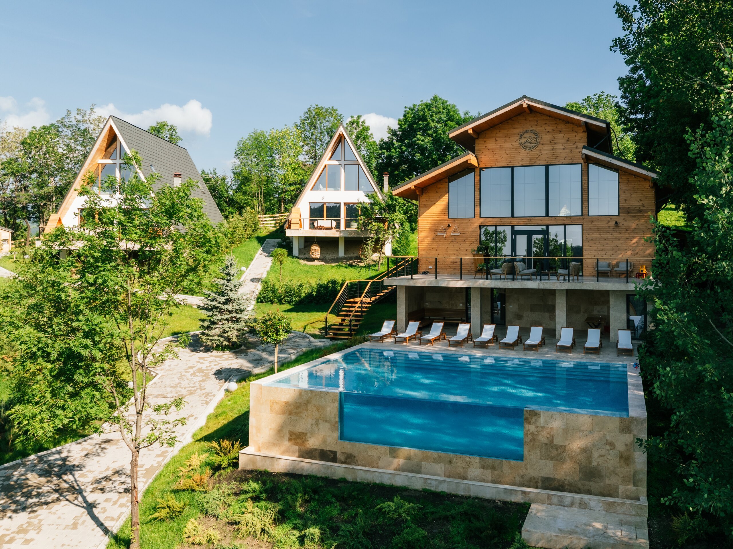 The Barn with its glass front and the blue outdoor pool below it, seen from above