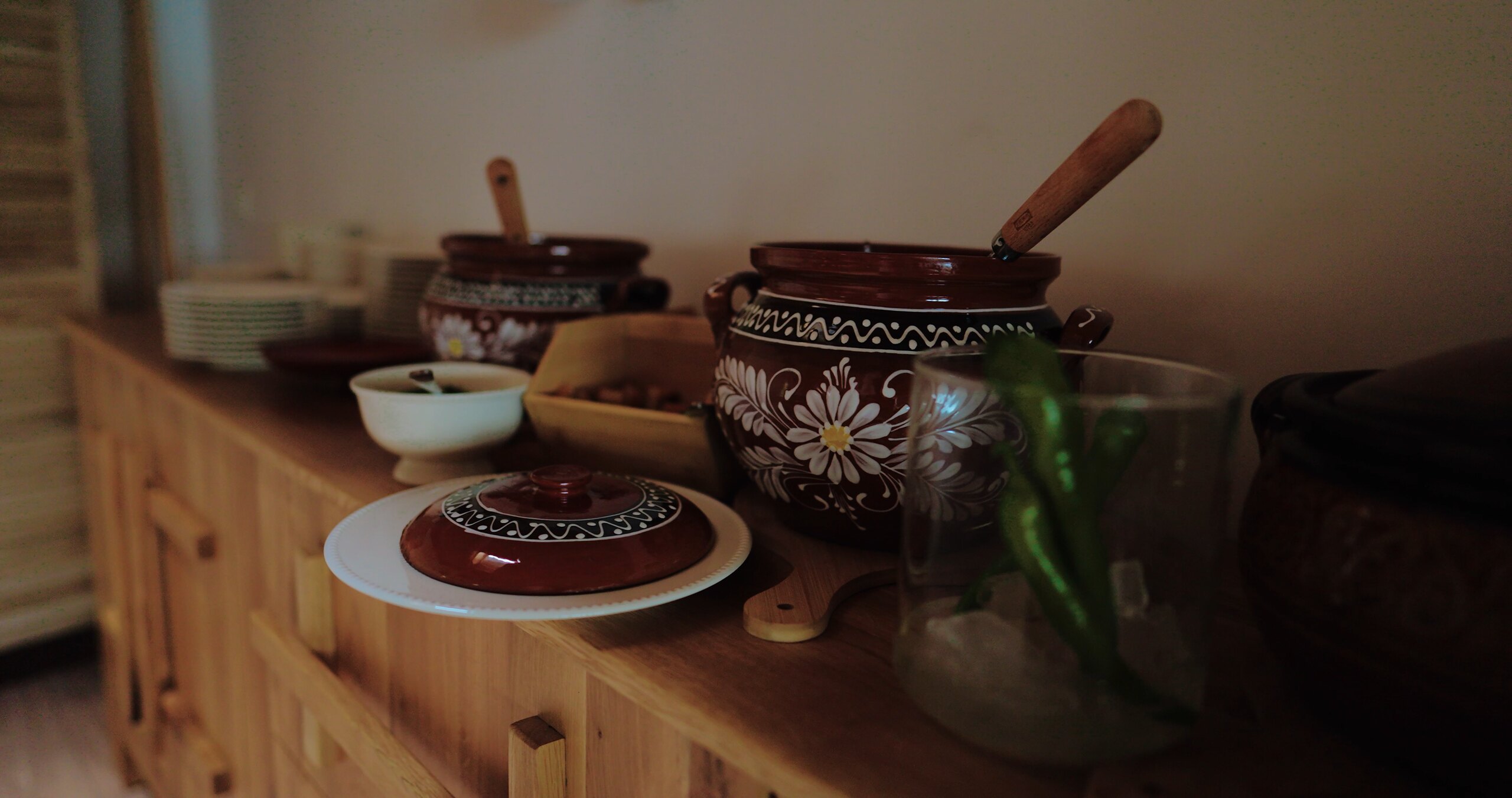 Clay bowls and a pot on a wooden kitchen counter