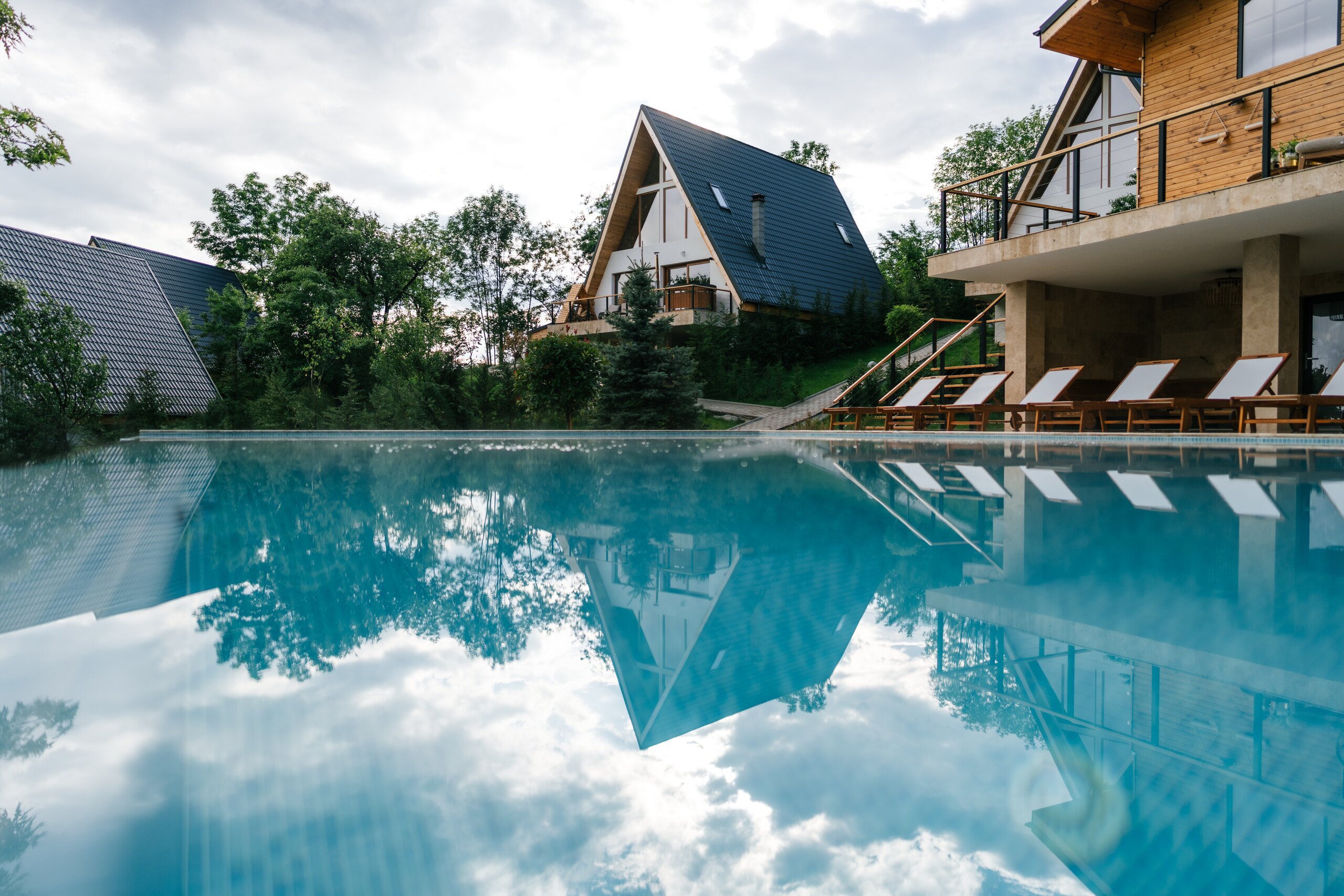 The outdoor pool reflecting the sky, the Barn and the A-frames behind it