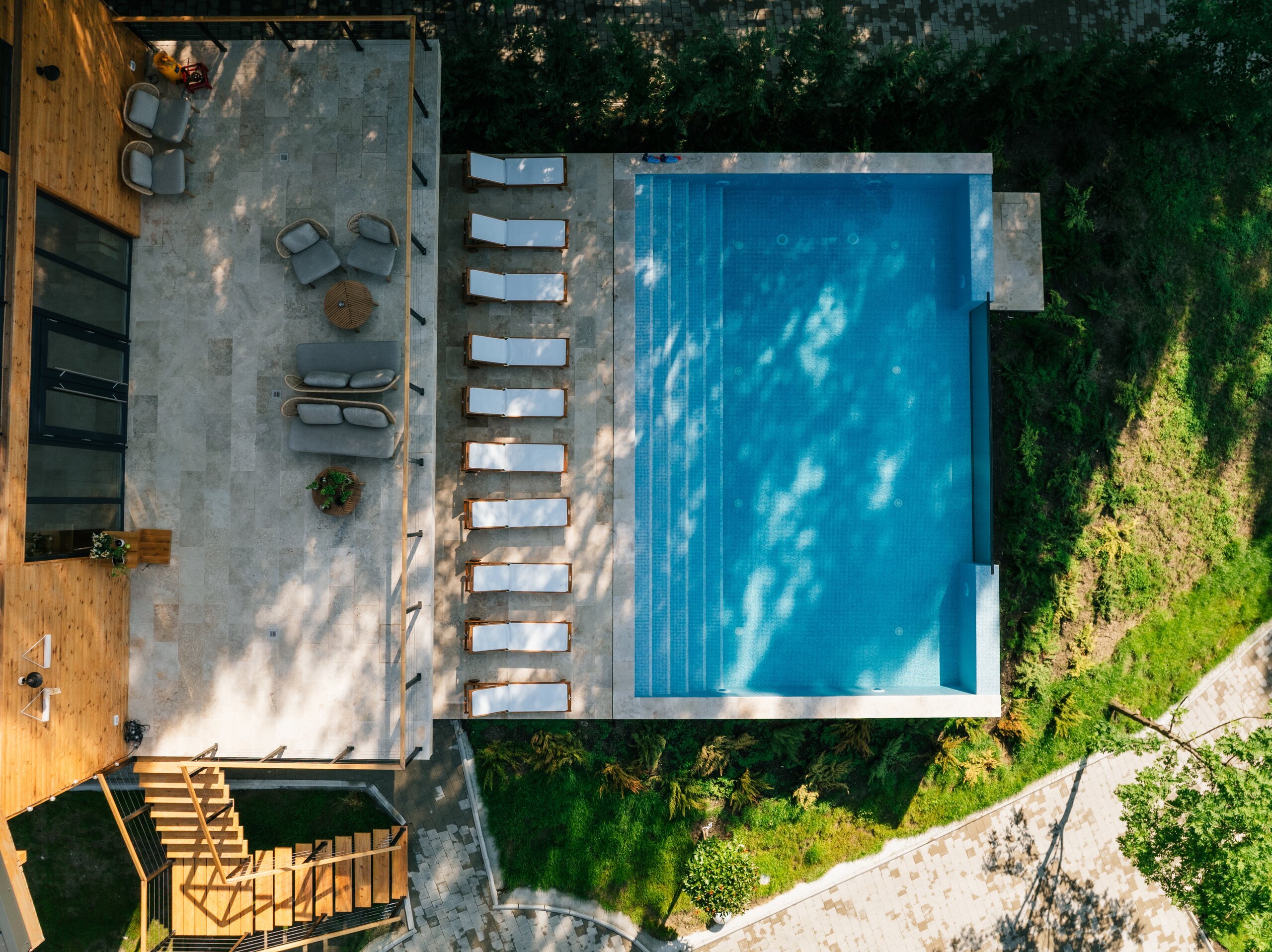 The outdoor pool and a row of white loungers seen from straight above