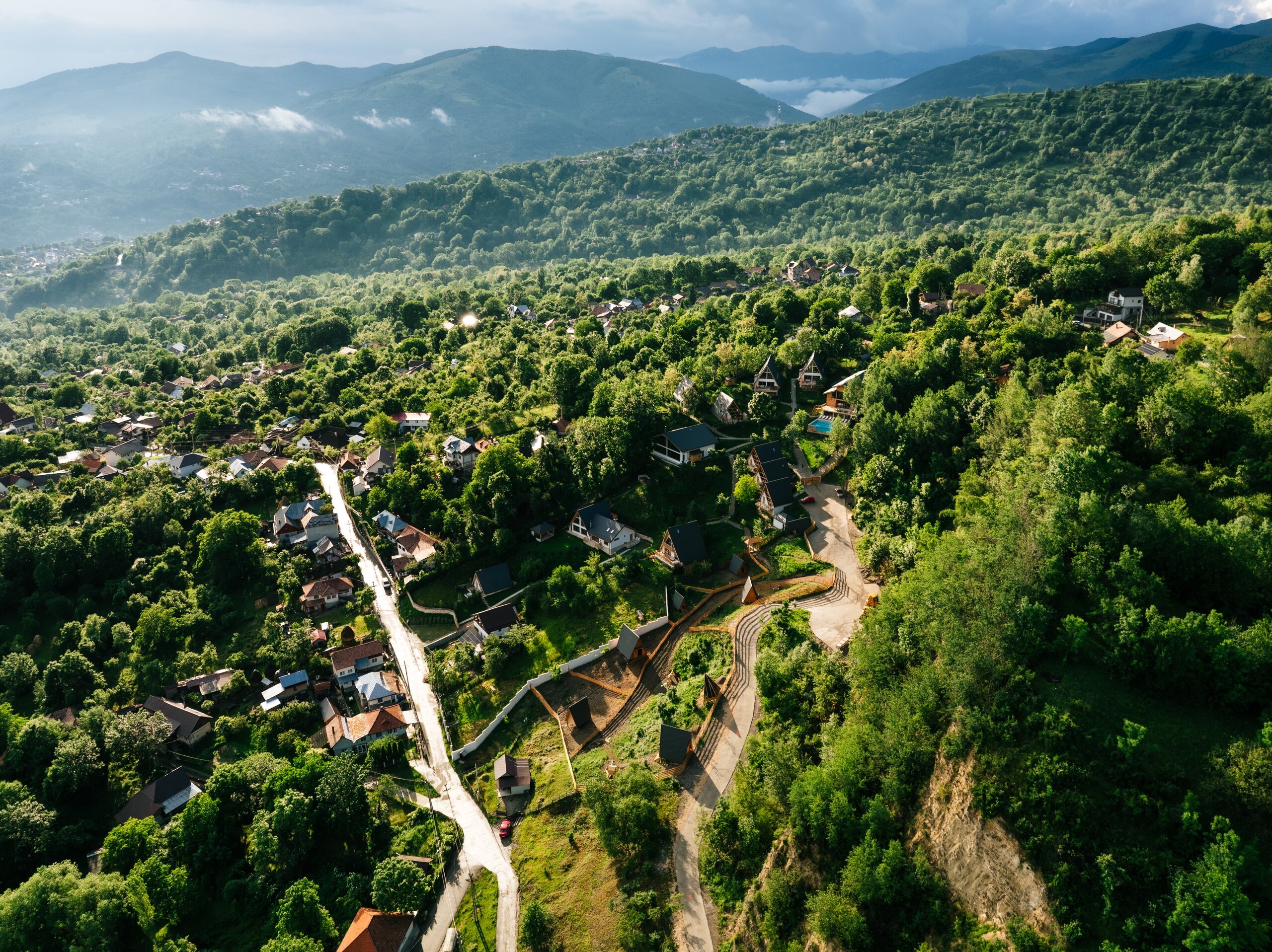 Aerial view of the village houses along a road, mountain ridges in the distance