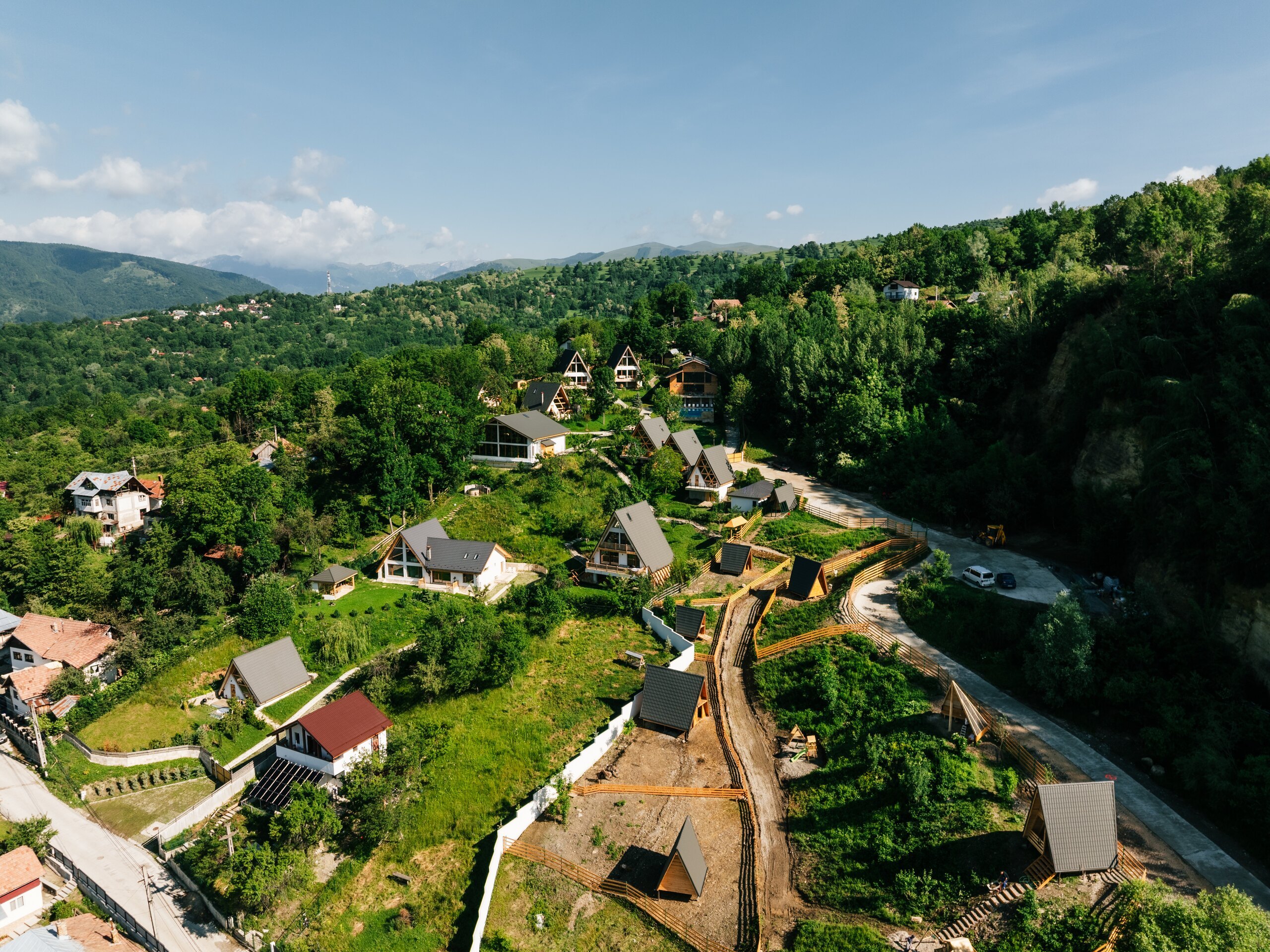 Wide view over the village houses, the road below and the mountains beyond